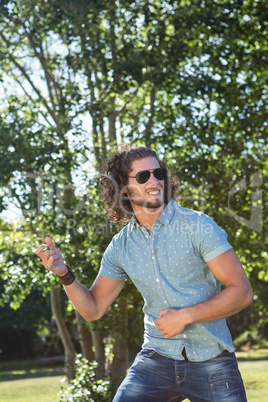 Young man playing air guitar in the park