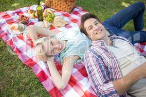 Happy couple lying together at the park