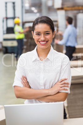 Female manager with arms crossed in warehouse