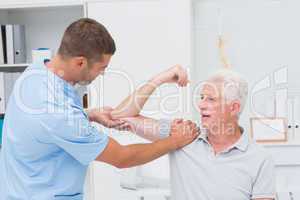 Physiotherapist giving massage to senior man