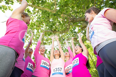 Smiling women running for breast cancer awareness