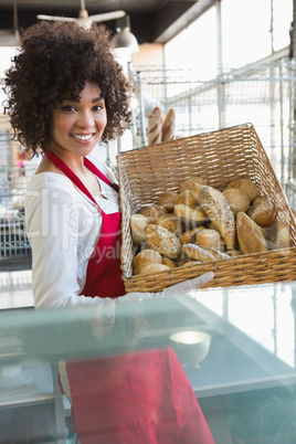 Pretty waitress carrying basket of bread