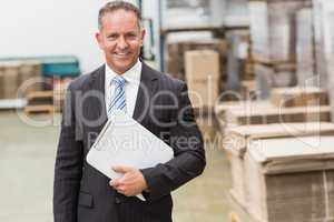 Portrait of a smiling boss holding clipboard