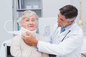 Doctor examining senior patient wearing neck brace