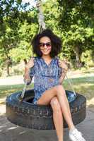 Pretty young woman in tire swing