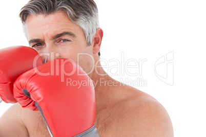 Fit man punching with boxing gloves