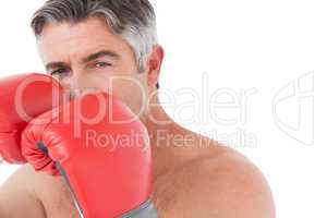 Fit man punching with boxing gloves