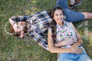 Young couple relaxing in the park smiling at camera