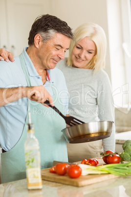 Happy mature couple making dinner together