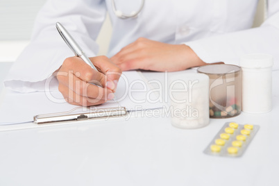 Vet writing on clipboard the prescriptions