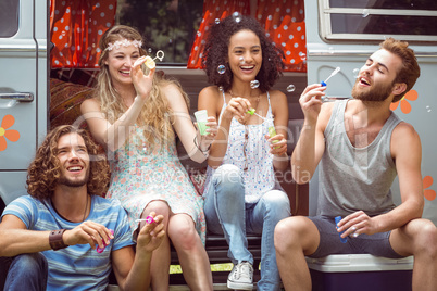 Hipsters blowing bubbles in camper van