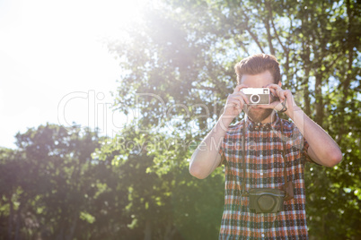 Handsome hipster using vintage camera