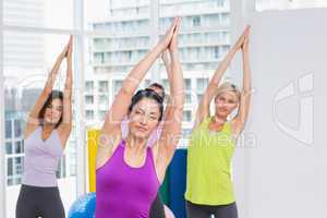 Women practicing stretching exercise in gym