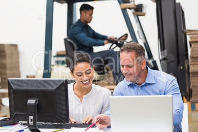 Warehouse managers working with laptop at desk