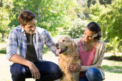 Happy couple with their dog in the park