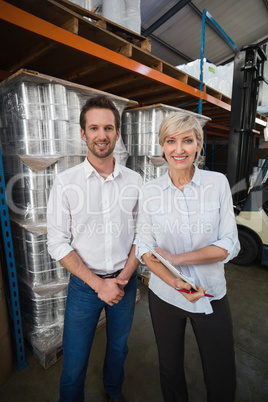 Smiling warehouse managers looking at camera