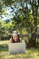 Pretty brunette using laptop in park