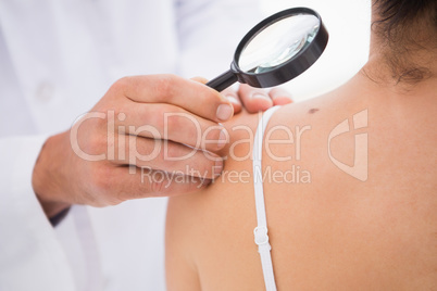 Doctor examining patient with magnifying glass