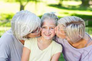 Happy family kissing little girl