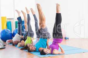 People doing Pilates exercises in gym