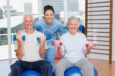 Happy female instructor with arms around senior couple