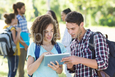 Smiling students using tablet pc