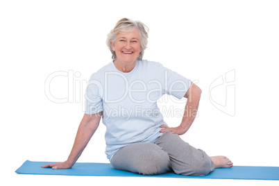Senior woman smiling on exercise mat