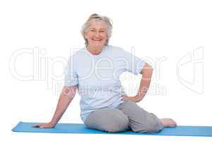 Senior woman smiling on exercise mat