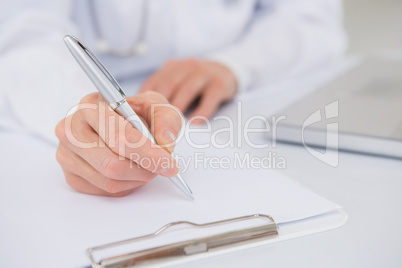 Doctor writing on a clipboard