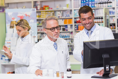 Team of pharmacists looking at computer