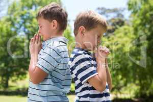 Little boys praying in the park