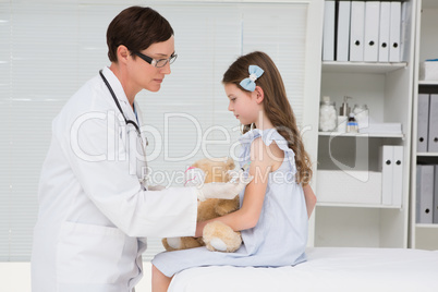 Doctor examining little girl