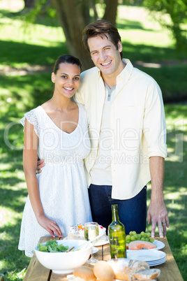 Happy couple smiling at the camera in the park