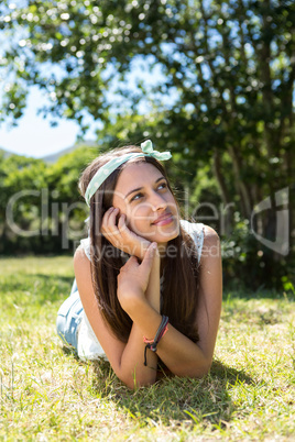 Pretty brunette thinking on the grass