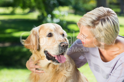 Happy blonde with her dog in the park