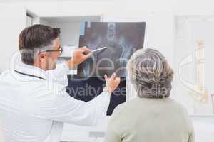 Doctor explaining x-ray to female patient
