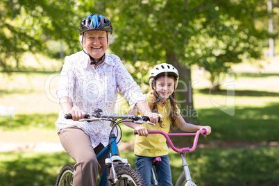 Happy grandmother with her granddaughter on their bike