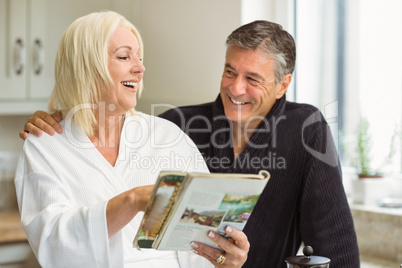 Mature couple reading magazine together in morning