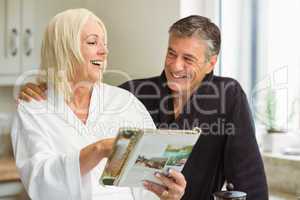 Mature couple reading magazine together in morning