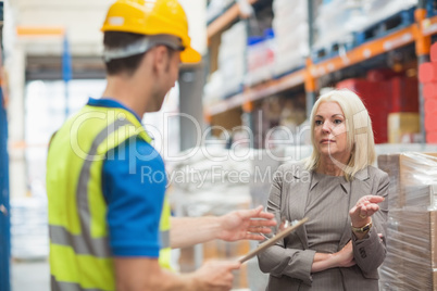 Worker with clipboard speaking with his manager