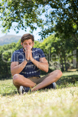 Handsome hipster blowing his nose