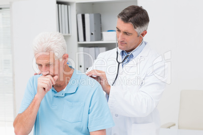 Doctor examining coughing senior patient