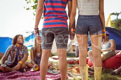 Hipster couple holding hands on campsite