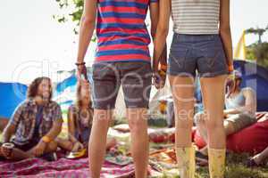 Hipster couple holding hands on campsite