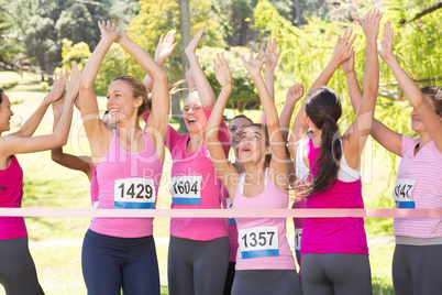 Smiling women running for breast cancer awareness