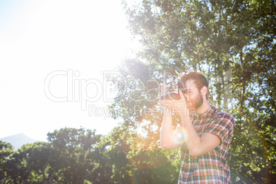 Handsome hipster using vintage camera