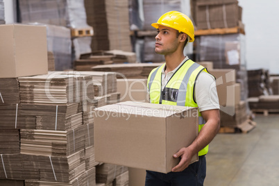 Worker carrying box in warehouse