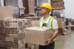 Worker carrying box in warehouse