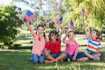 Happy little friends waving american flag