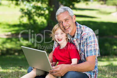 Happy father using laptop with his son